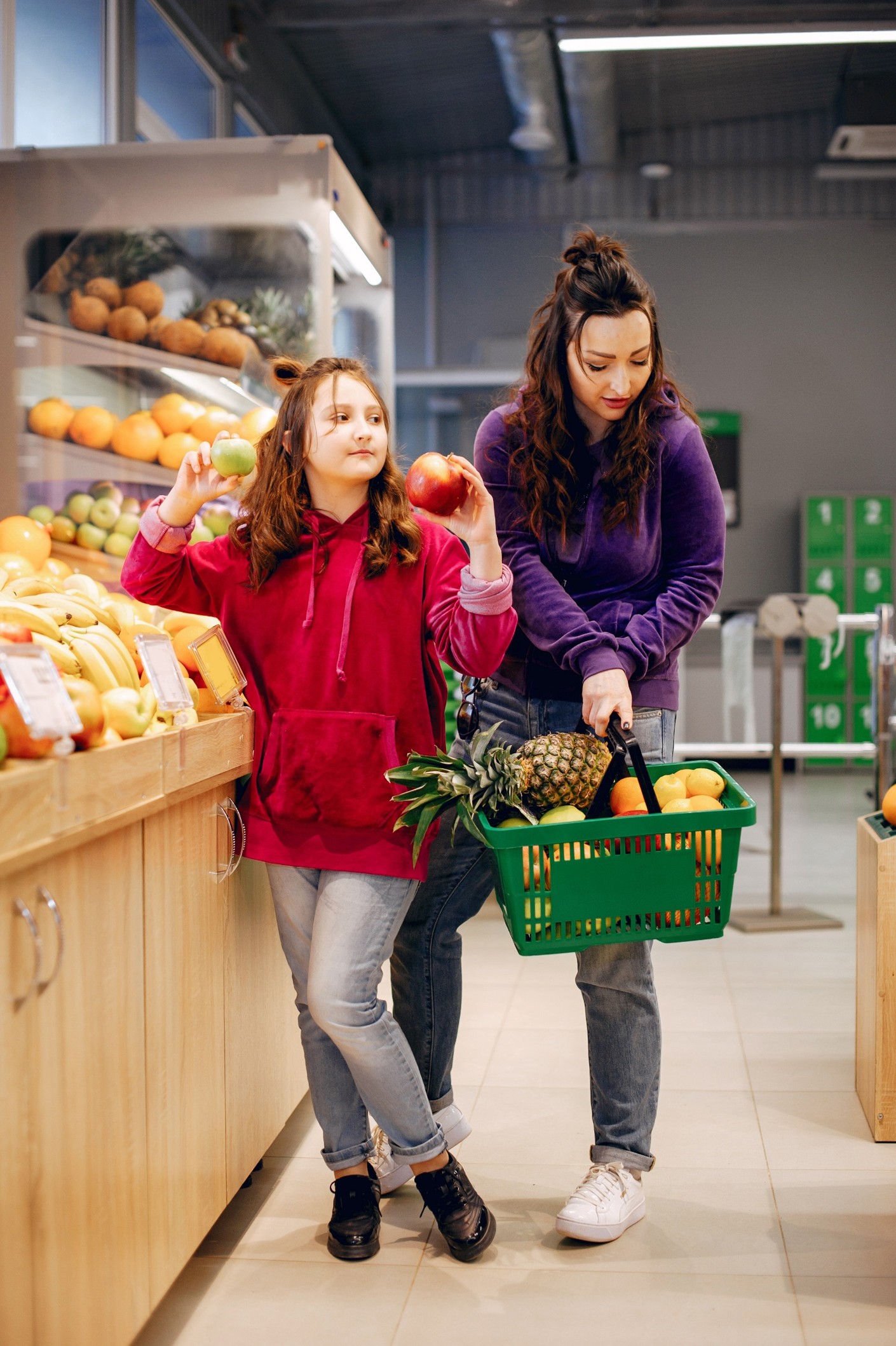 A mother and daughter shopping for fresh fruit at Al Dupane Souq